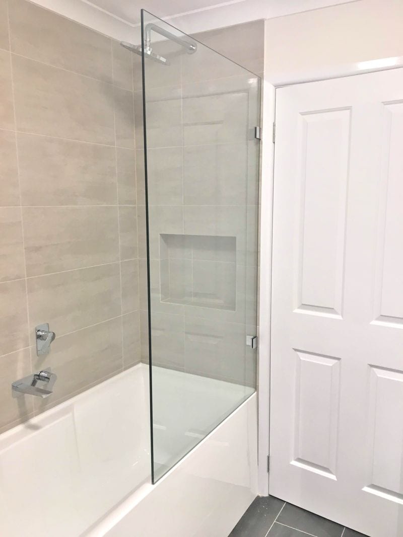Fixed shower glass panel over a bathtub