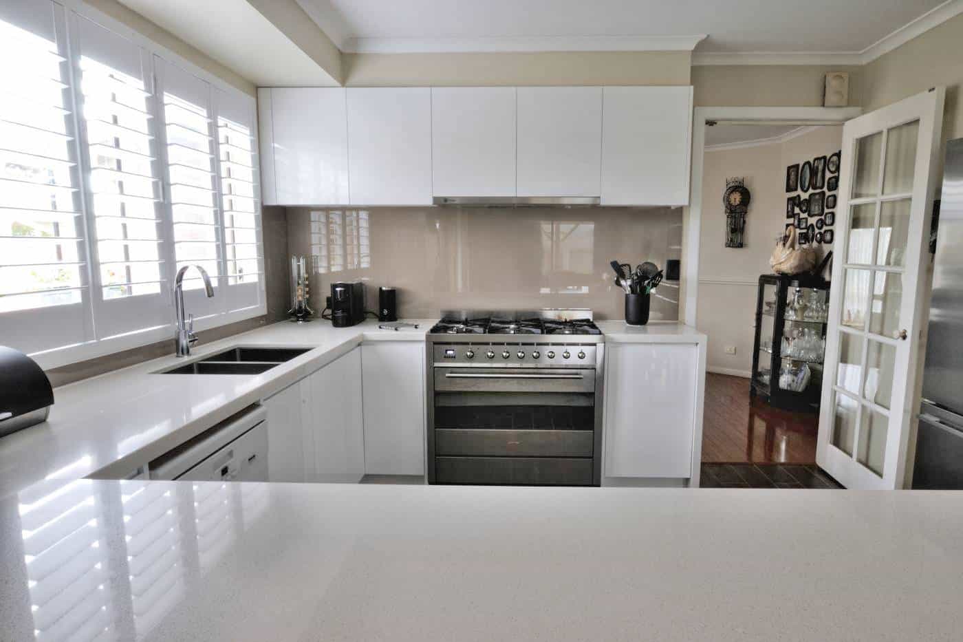 Beige glass splashback in a white kitchen in Darley