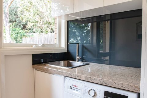 Dark blue painted glass splashback in a Melbourne laundry