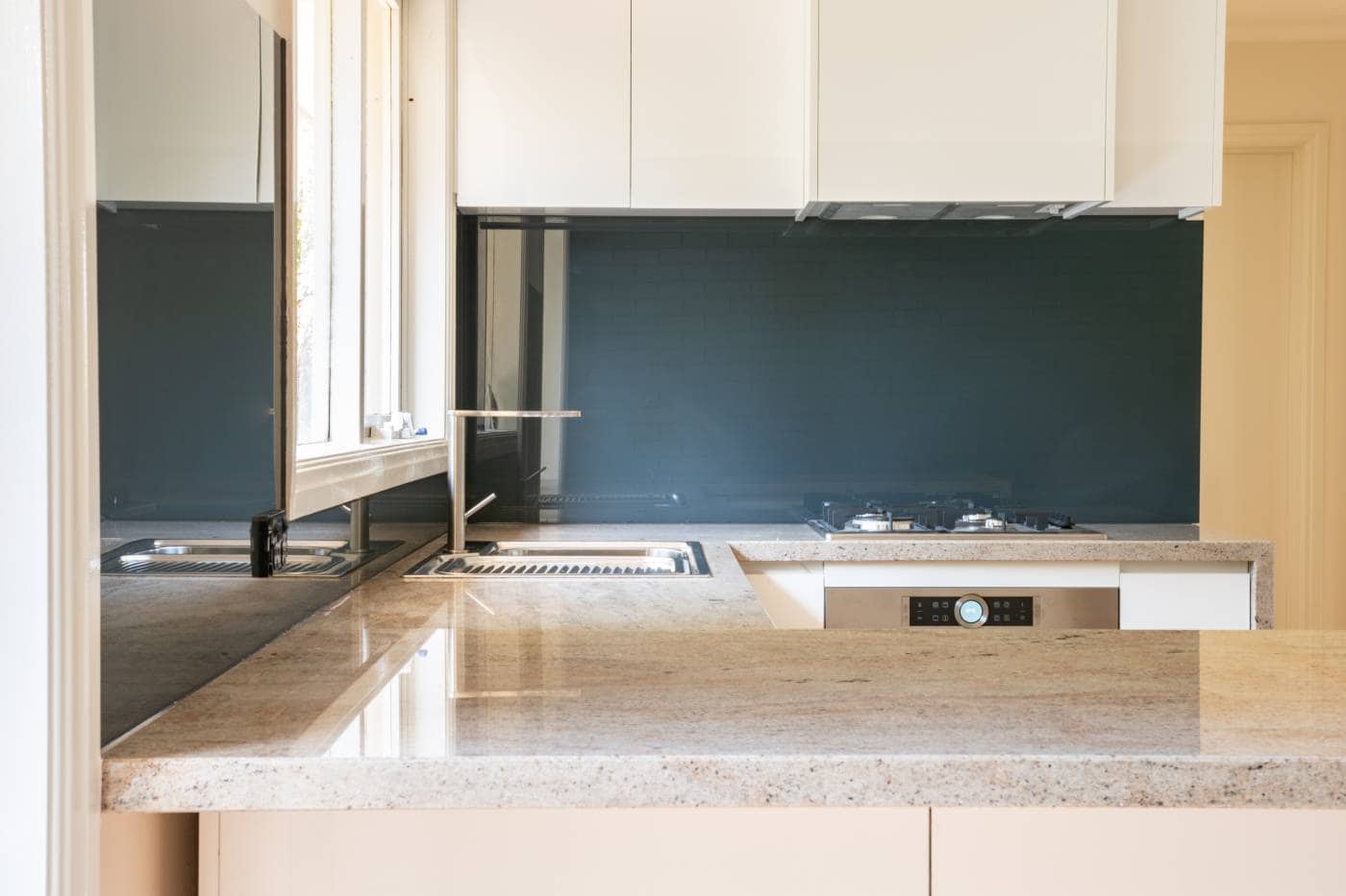 aqua-glass-splashback Dark kitchen splashback in a beige coloured kitchen in Melbourne