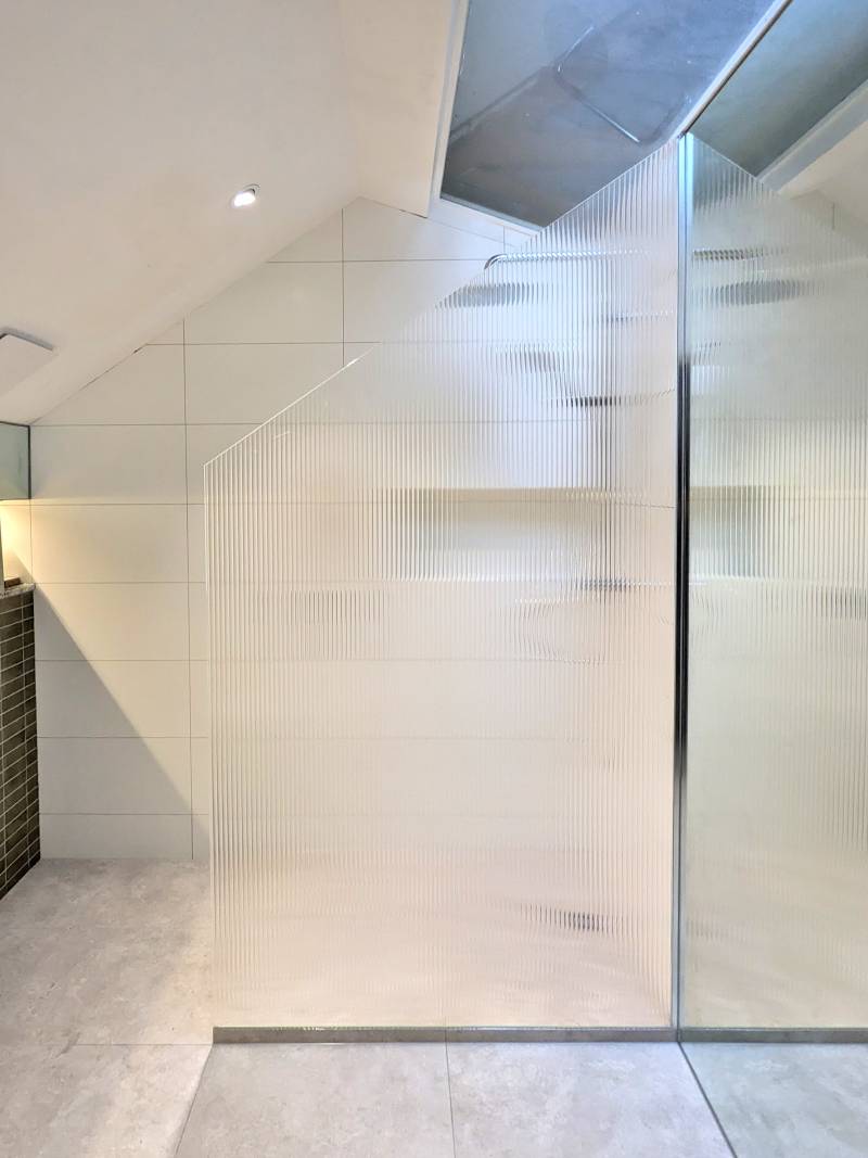 Fluted shower screen with a large rake that follows the ceiling