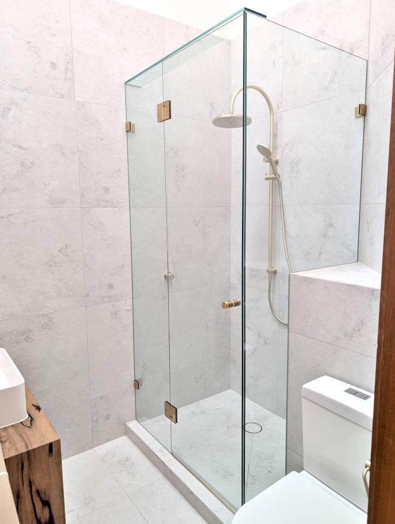 Brushed brass frameless shower screen installed in Keilor Downs bathroom