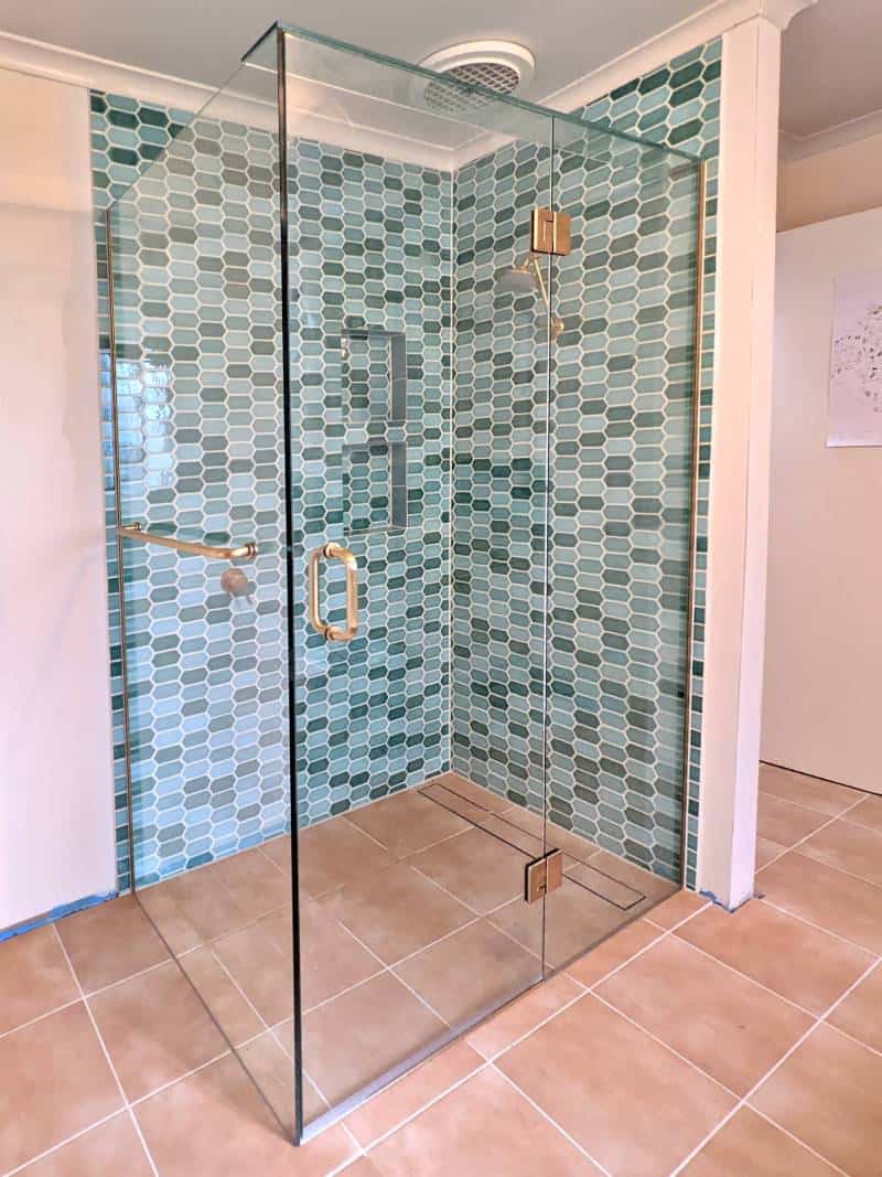 Frameless shower screen with brushed gold hardware installed in Fairfield