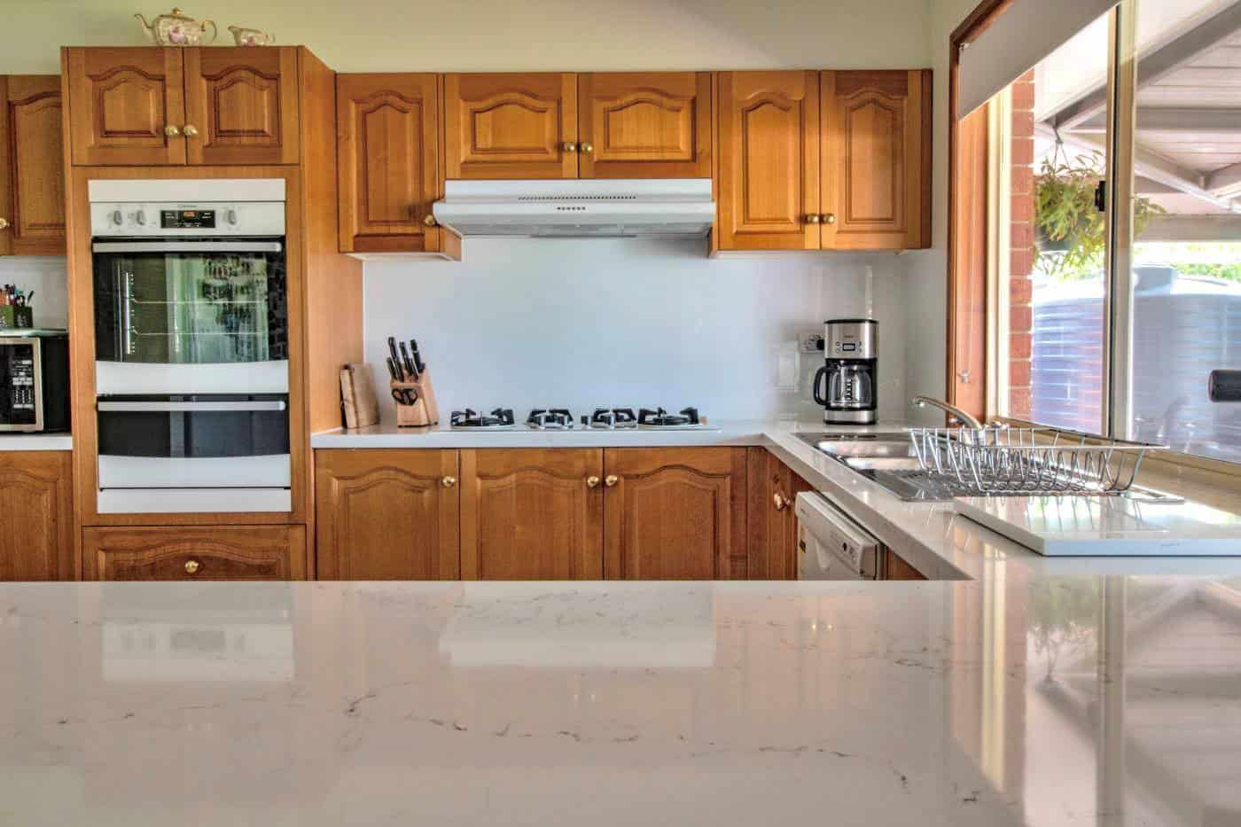 White glass splashback in a refurbished timber kitchen