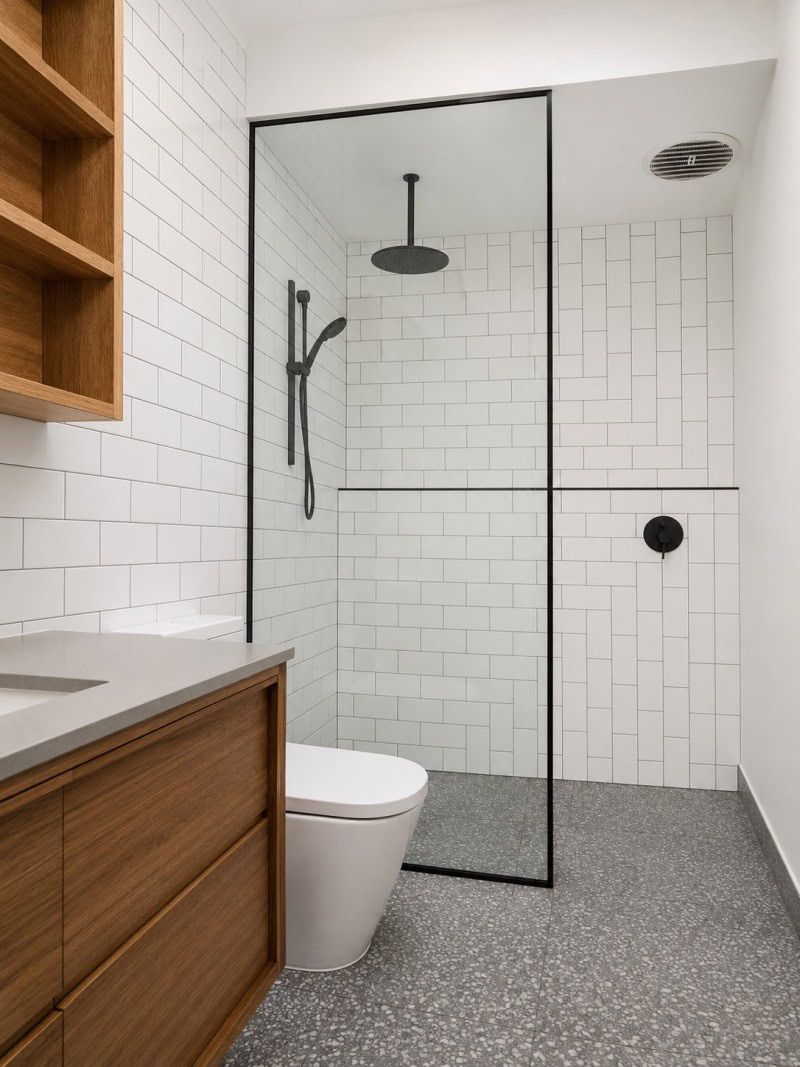 Black frame shower screen with reeded glass installed in Melbourne bathroom