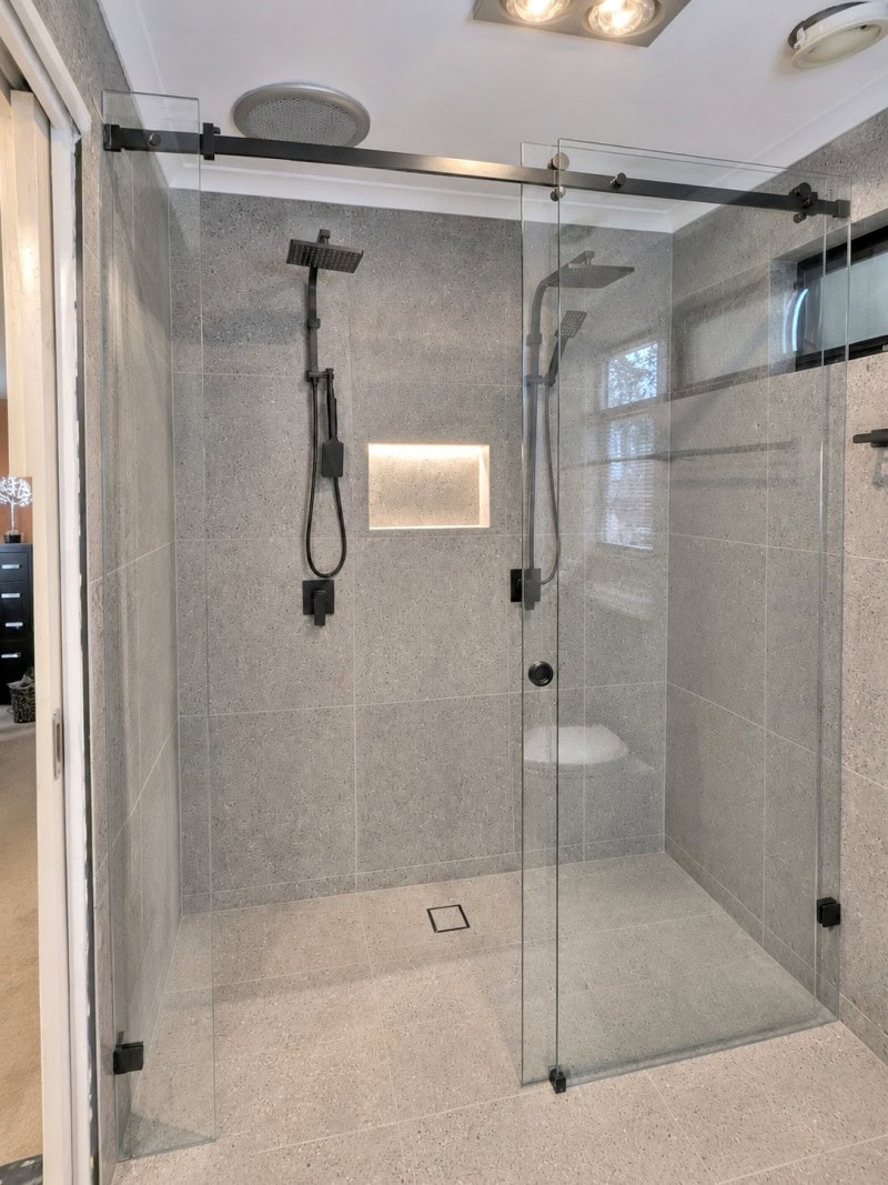 Custom made frameless sliding shower screen measured to suit tiled bathroom opening