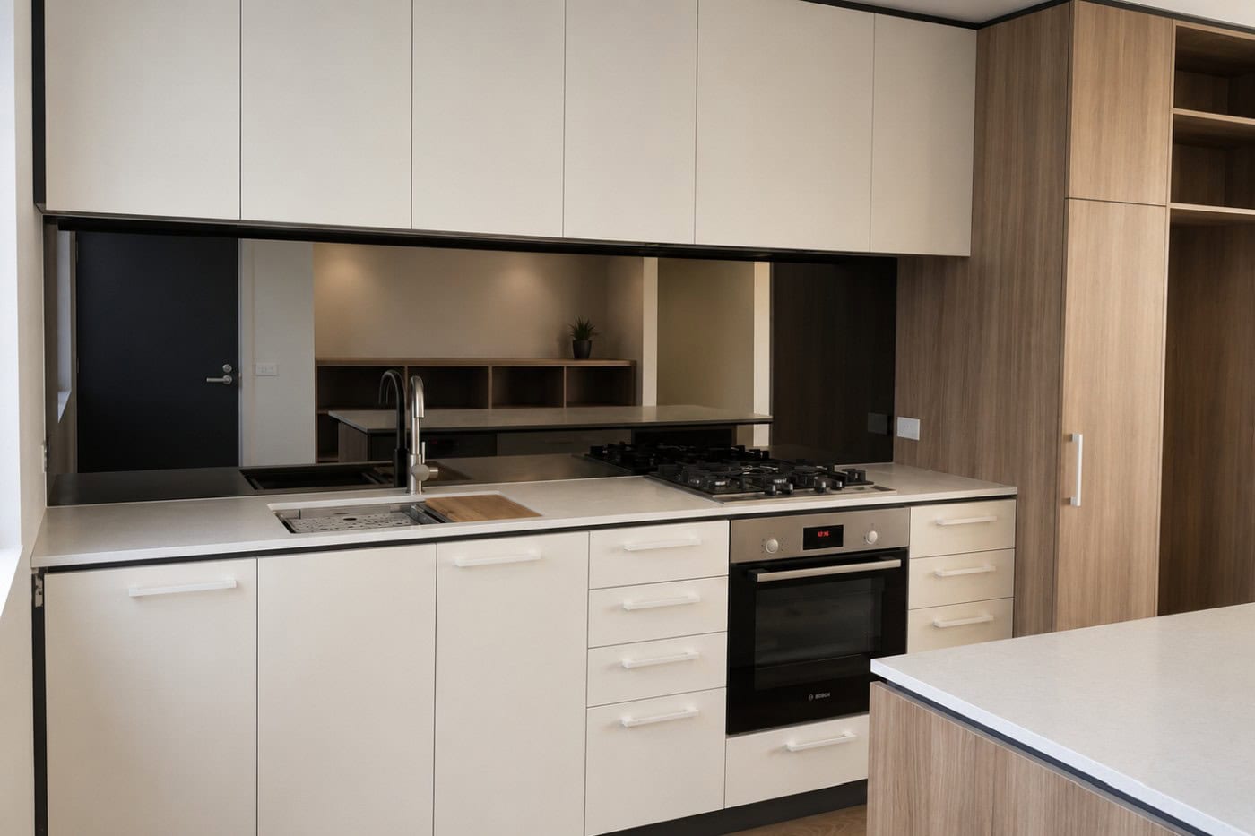 Bronze mirror splashback with warm kitchen cabinetry
