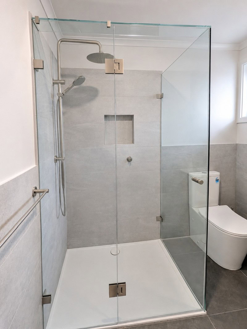 Brushed nickel frameless shower screen installed in Coburg bathroom