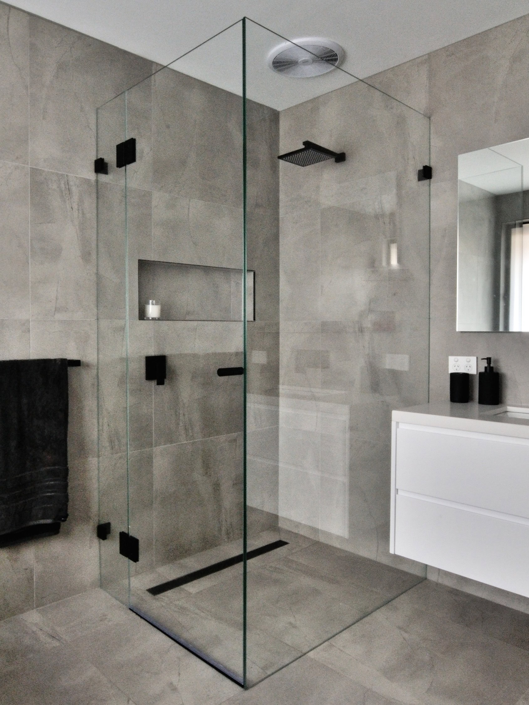 Black low iron frameless shower screen installed in Kealba bathroom