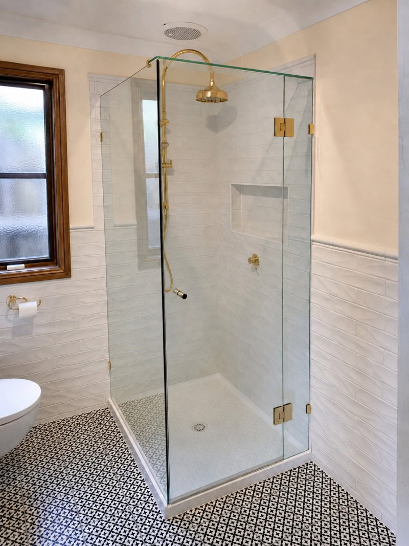 Frameless shower screen with brushed brass hardware installed in Sunbury bathroom