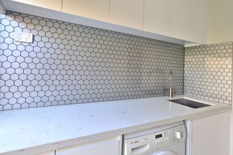 Hexagon pattern printed glass splashback in a laundry