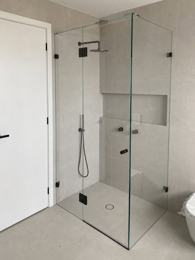 Low iron glass frameless shower screen with black hardware installed in Kurunjang bathroom