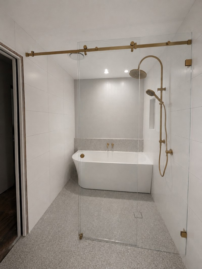 Low iron frameless sliding shower screen with brushed brass hardware installed in Bacchus Marsh bathroom