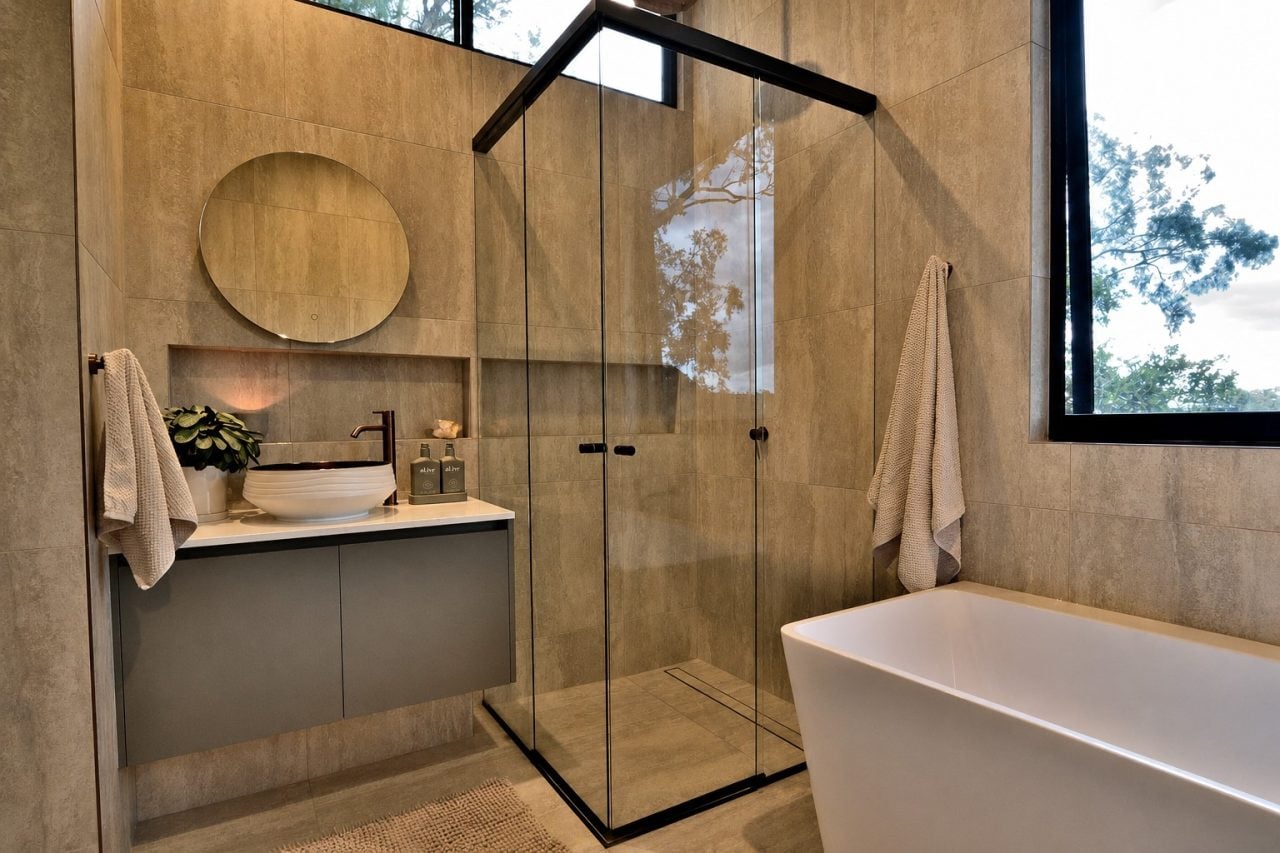 Black frameless corner-entry sliding shower screen installed in a Melbourne bathroom