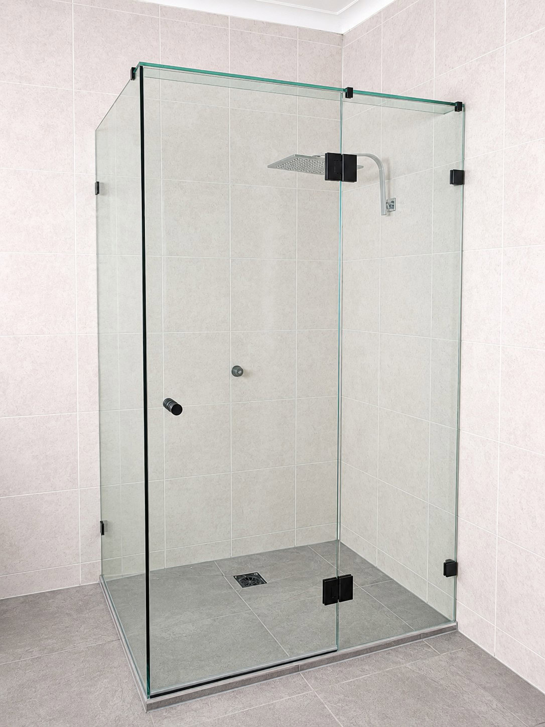 Black frameless shower screen installed in Altona North bathroom