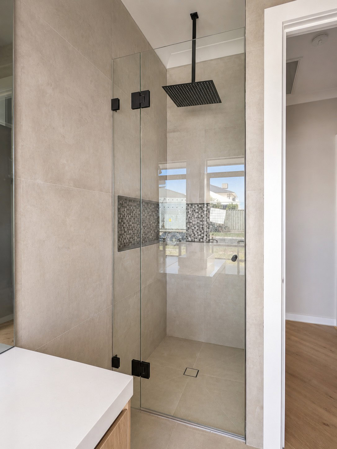 Matt black frameless shower screen installed in Maddingley bathroom