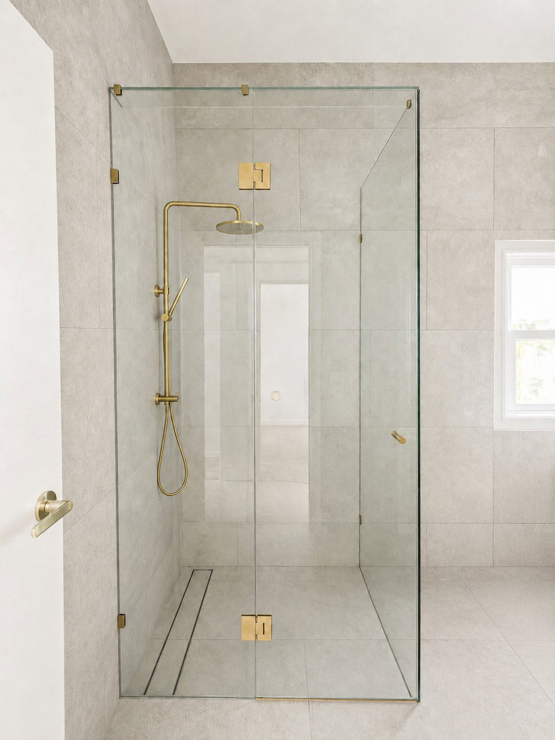 Brushed brass bathroom frameless shower screen installed in Newport