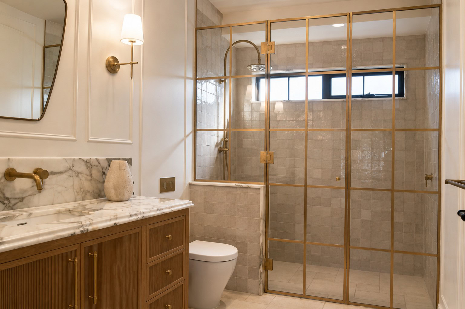 Stepped low iron glass enclosure with raw brass framing in the rear ensuite