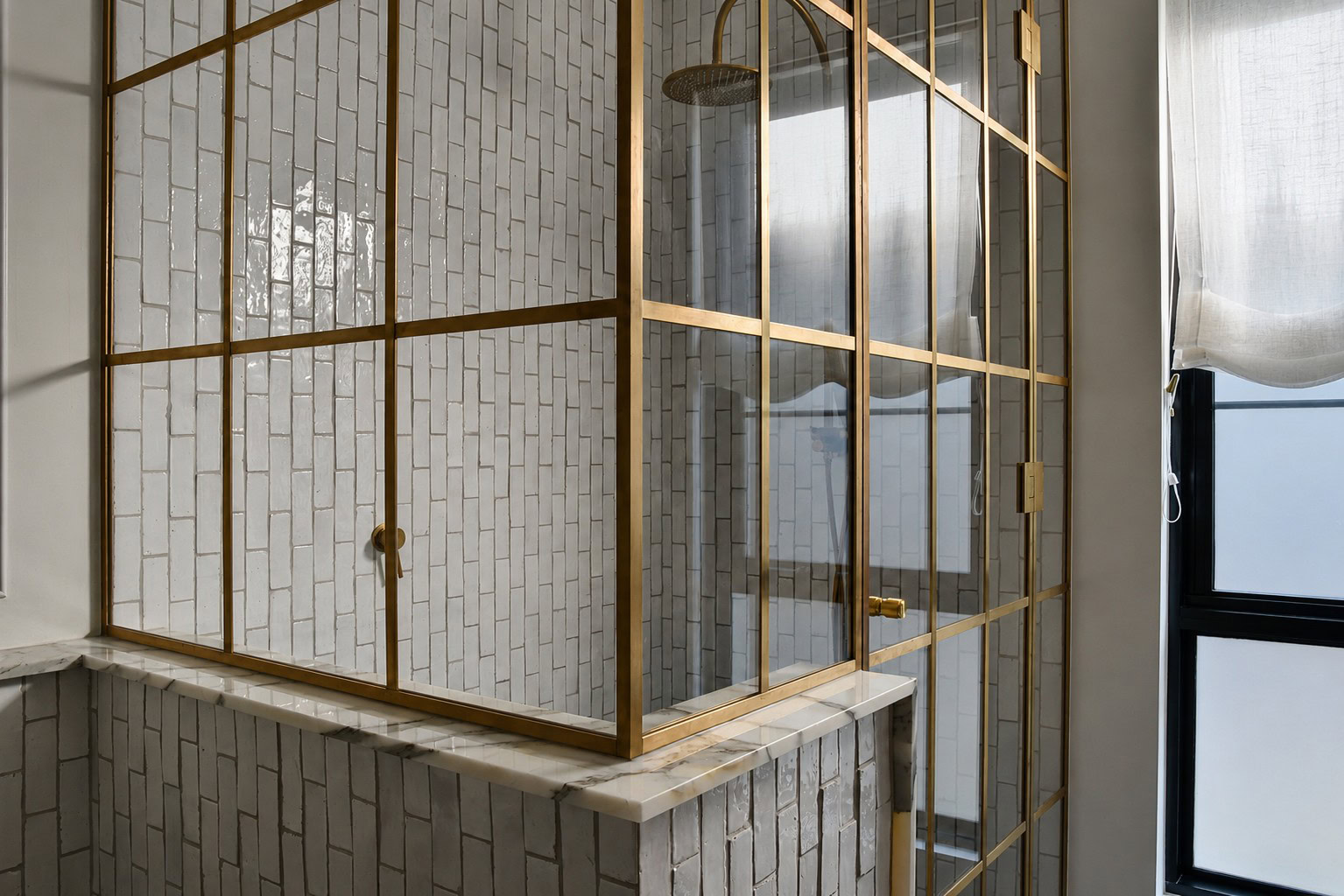 Close view of the raw brass corner and glass return panel