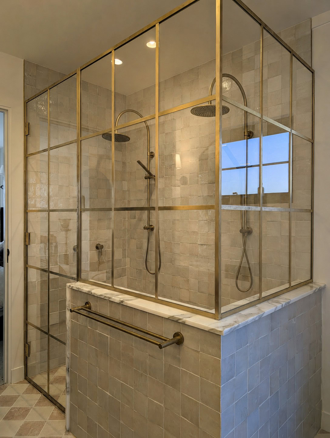 Low iron glass corner shower screen with raw brass grid detailing