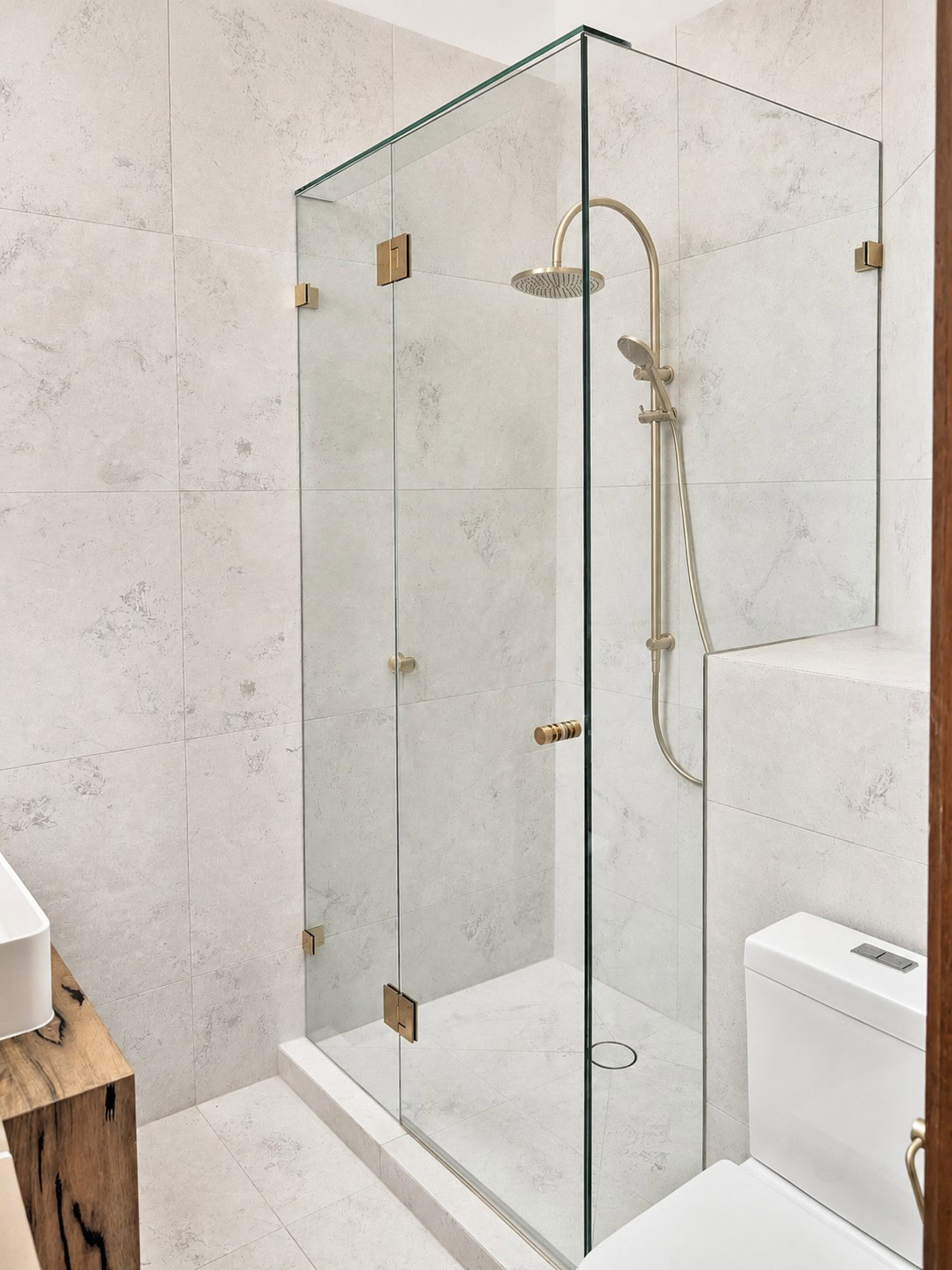 Brushed brass frameless shower screen installed in Keilor Downs bathroom