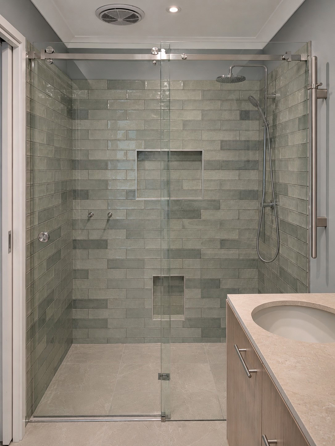 Sliding frameless shower screen with chrome hardware in a Gisborne bathroom
