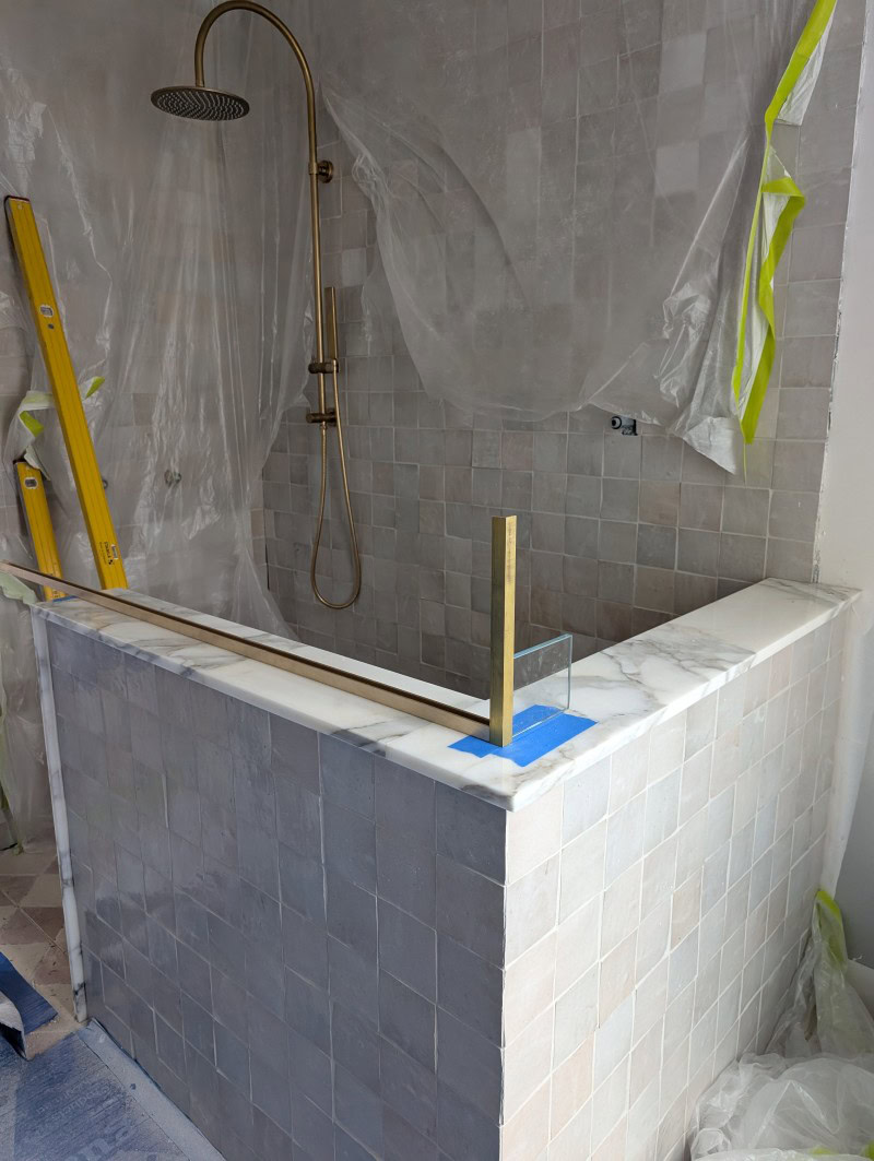 Raw brass channels positioned in the front ensuite before glass installation