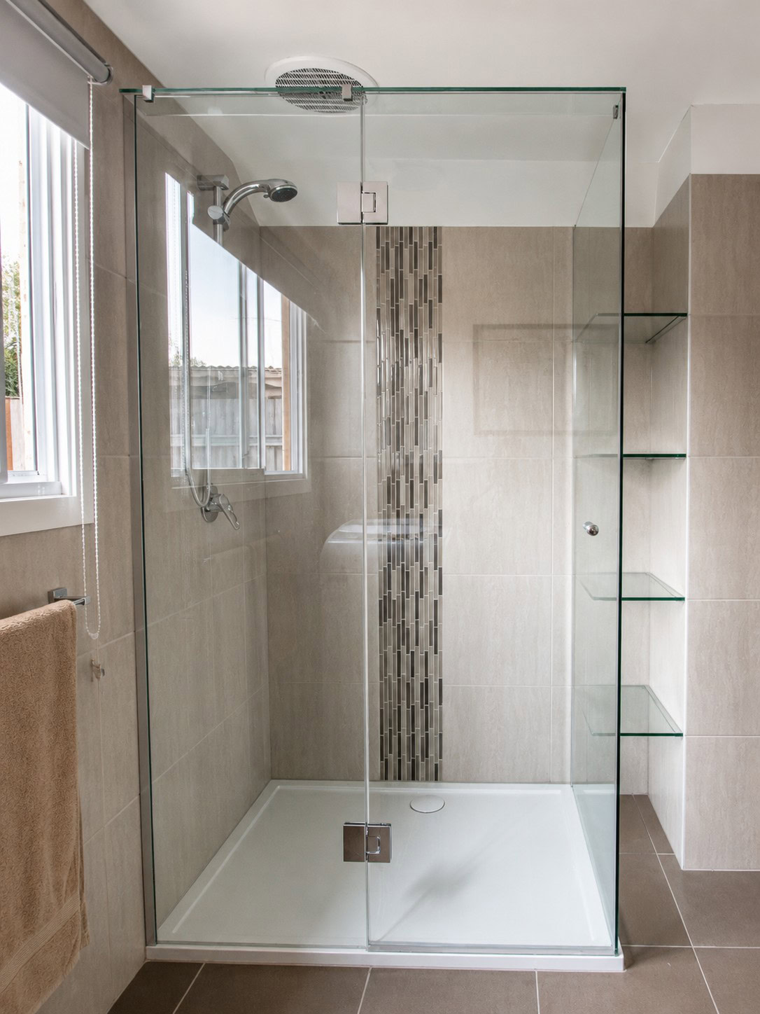 Custom chrome frameless shower screen with glass shelving installed in Sunshine North