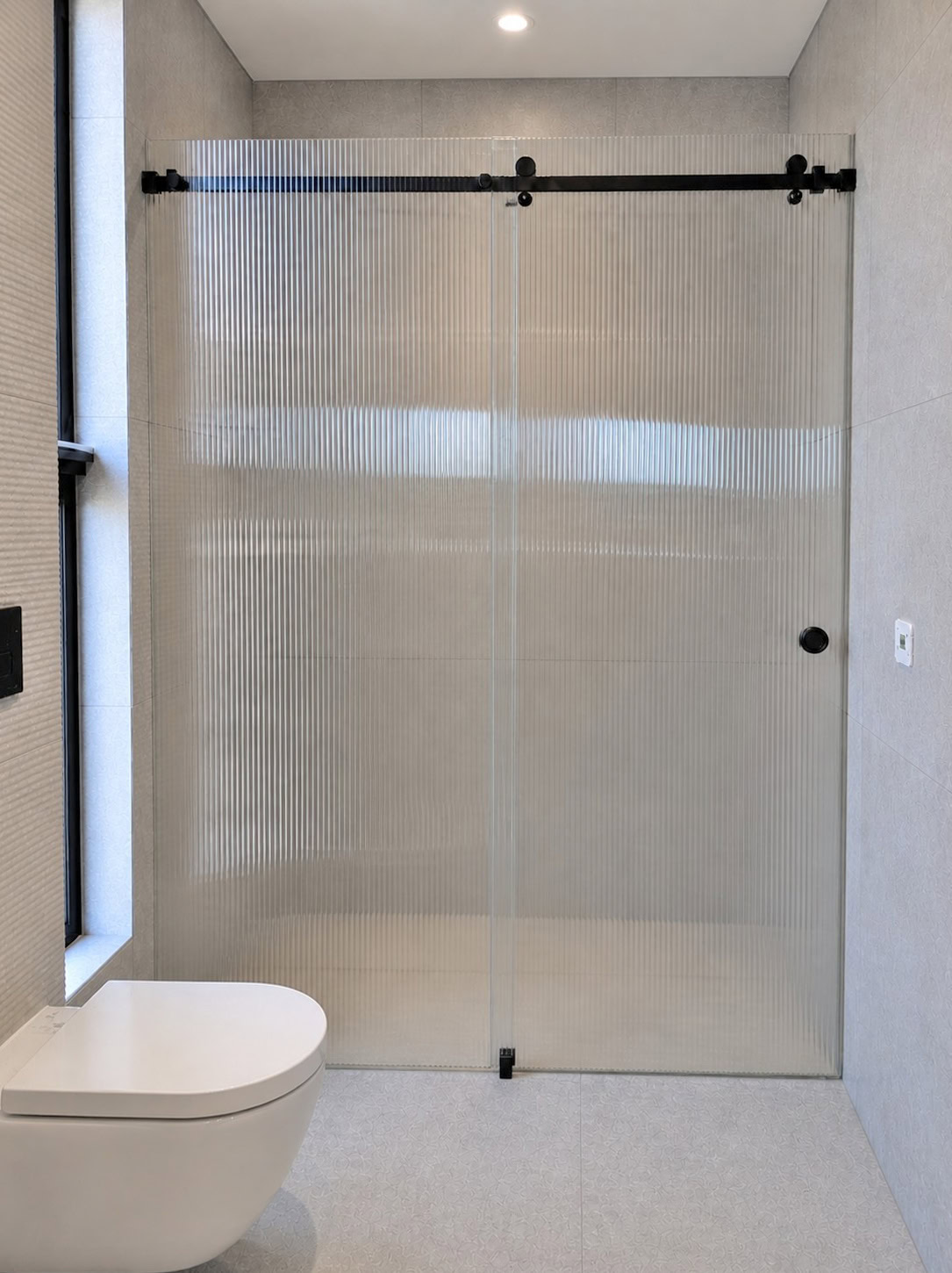 Fluted glass sliding shower screen installed in Yarraville bathroom renovation
