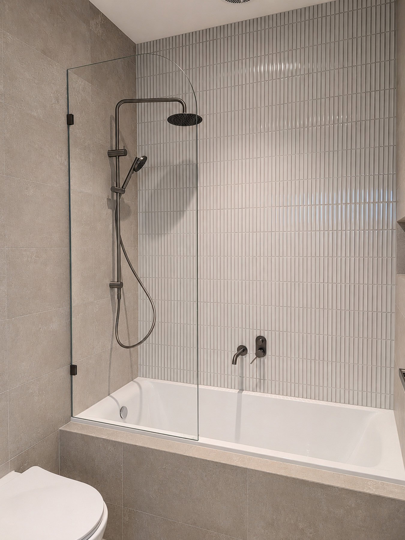 Over bath fixed shower screen with curved top installed in Windsor