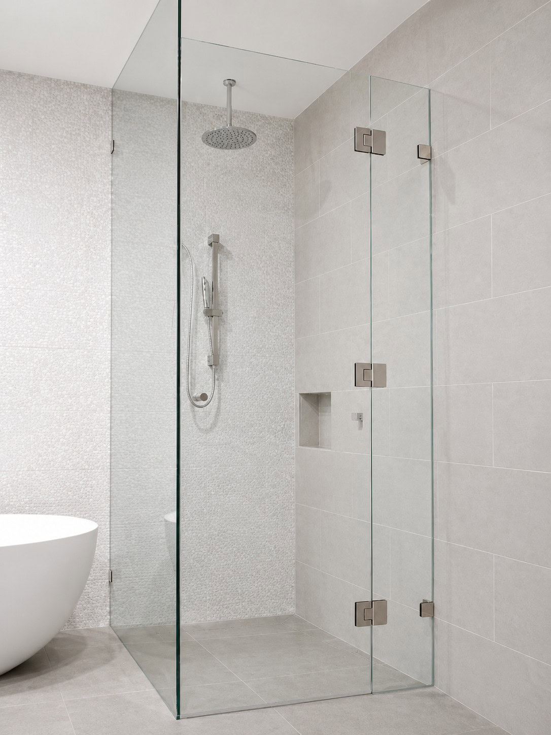 Full-height hinged shower screen installed in Essendon