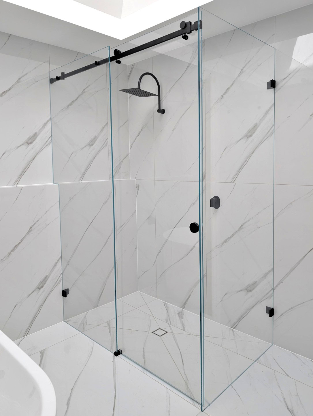 Low-iron sliding shower screen with black hardware installed in Parwan