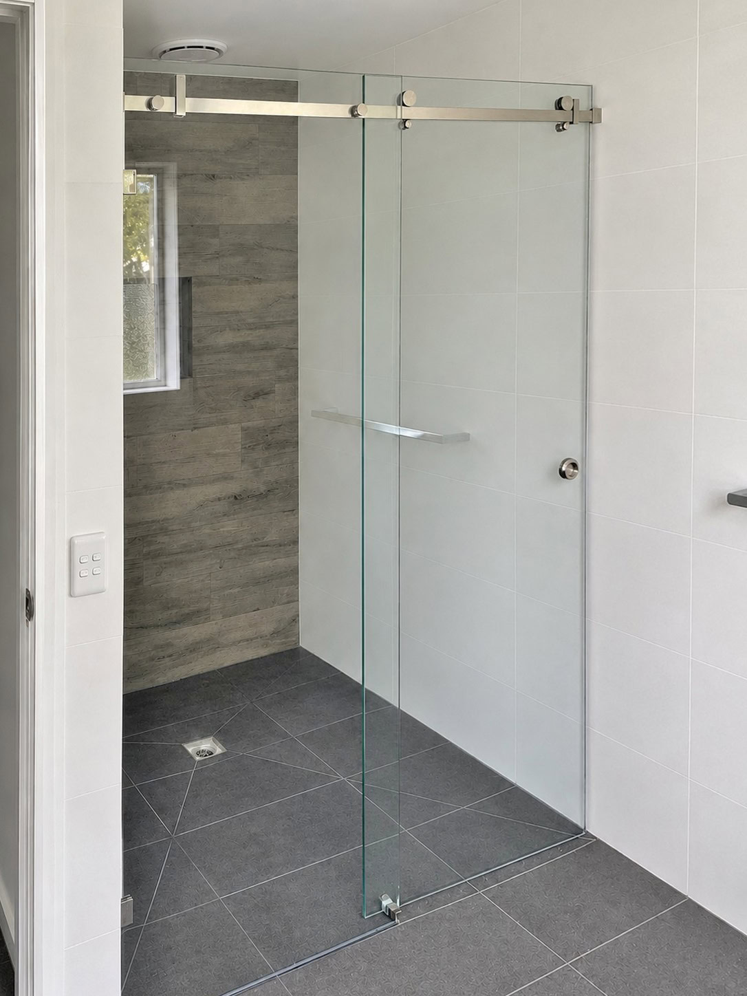Sliding frameless shower screen installed in Maddingley bathroom
