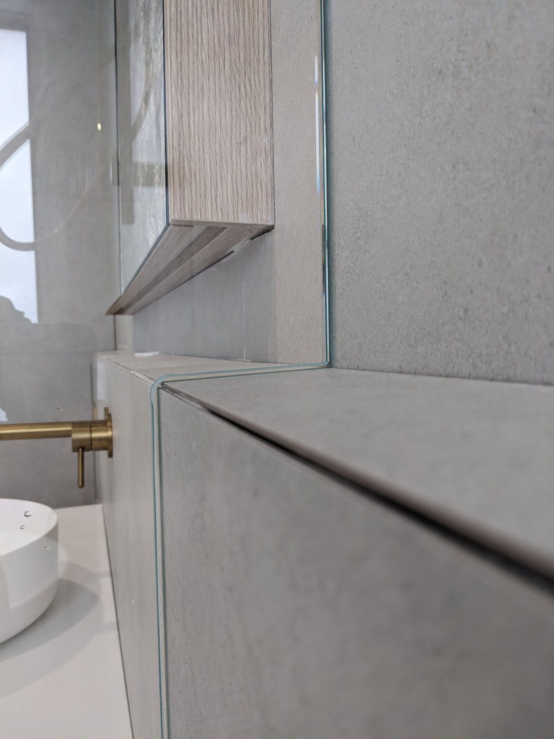 Custom shower screen glass cut around a bathroom ledge shelf