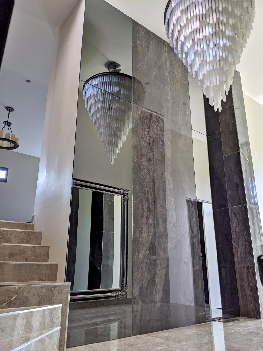 Large format grey mirror feature wall installed around tiles